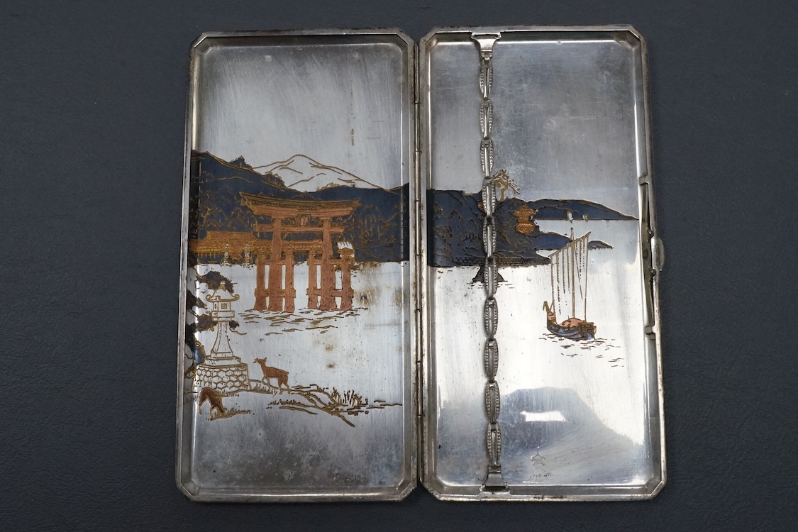 An early to mid 20th century Japanese mixed metal cigarette case, with Temple scene by the water with deer, engraved 'sterling' on the interior, 15.9cm, gross weight 5.8oz.